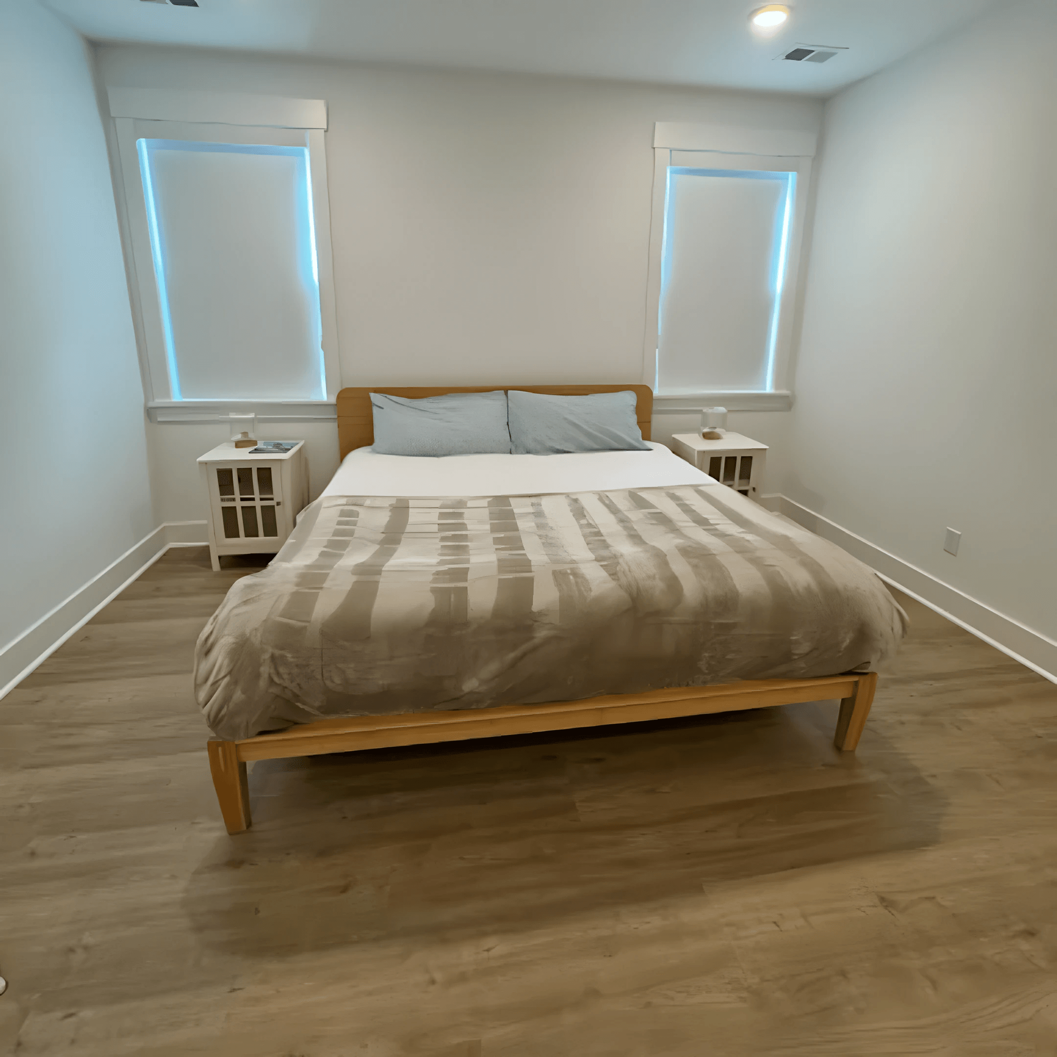 Guest bedroom with a freshly made bed and spotless floors, ready for the next guest