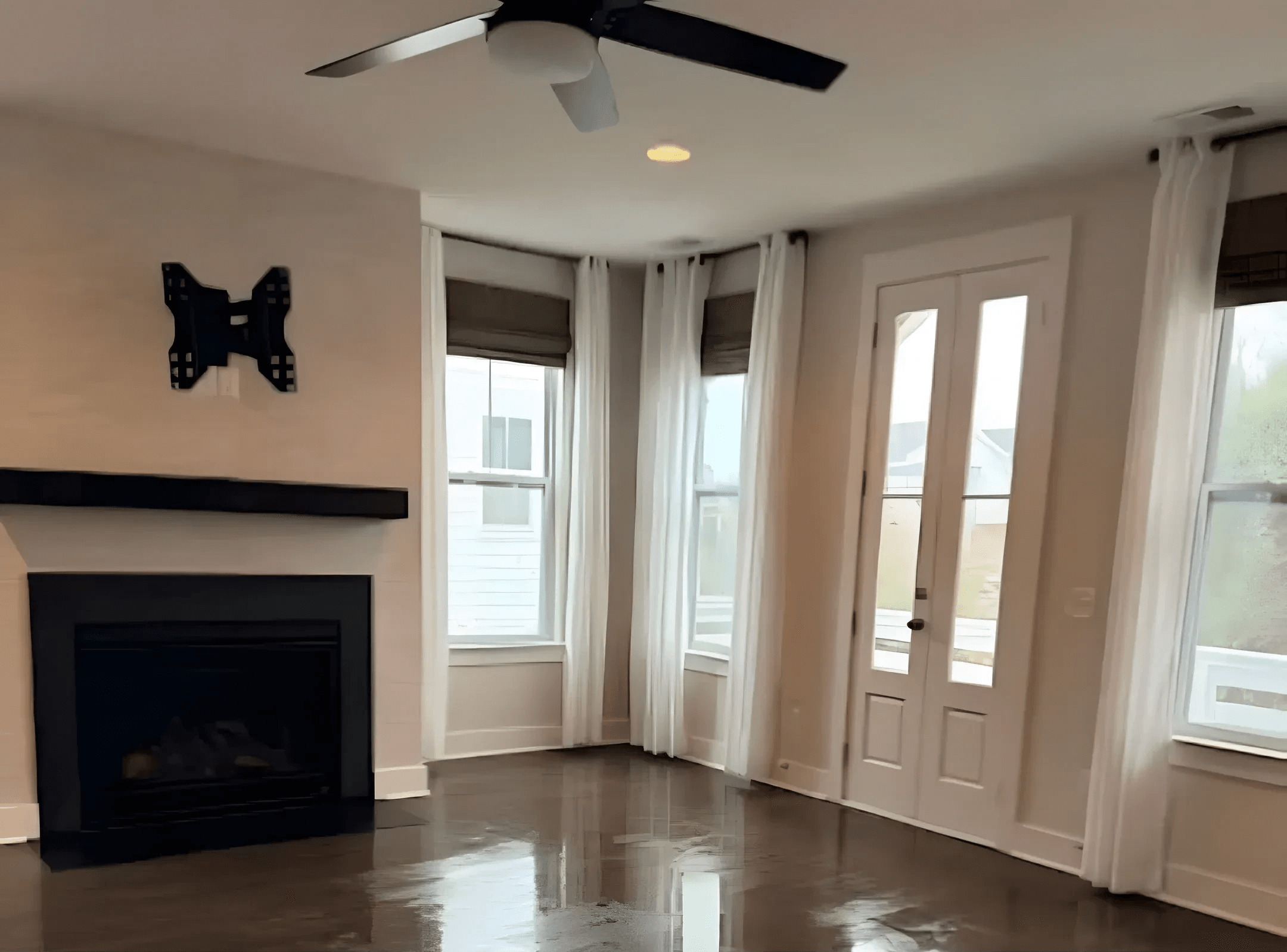 Living room with a fireplace and polished dark hardwood floors, cleaned by Harbor Home Cleaners
